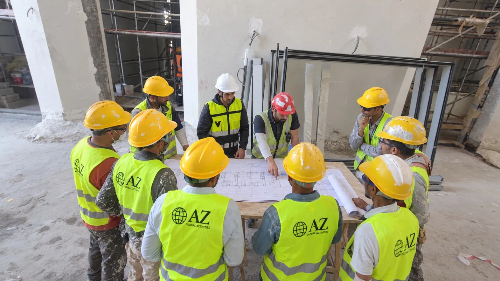 Briefing d'équipe sur site, ouvriers en gilets AZ Global Activities